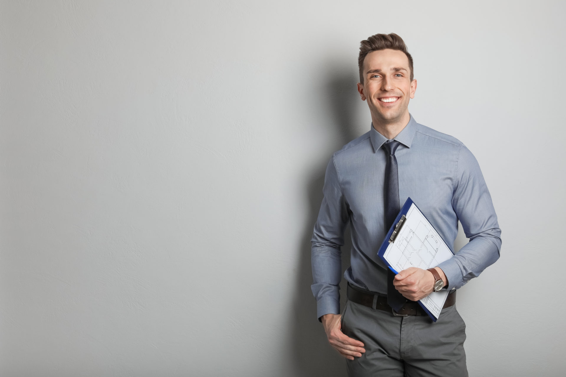 Male,Real,Estate,Agent,With,Clipboard,On,Grey,Background
